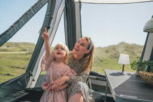Mutter mit Kind vor dem Zelt