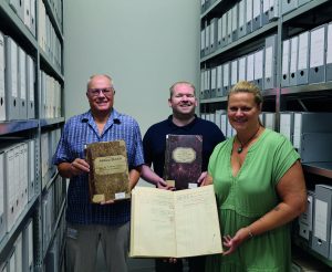 Archivleiter Konstantin Huber (links) mit Simon Kretz und Nicola Ratz freuen sich auf die Menschen, die sich für den neuen Schatz interessieren: die Brandversicherungs-Unterlagen aus dem Enzkreis.