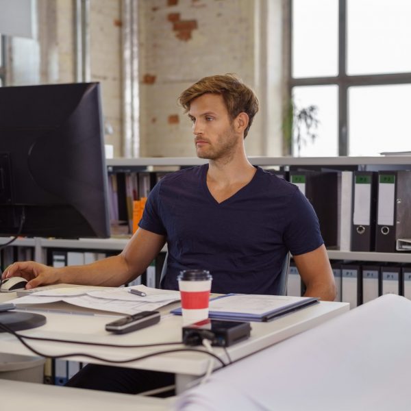 geschäftsmann am schreibtisch und arbeitet konzentriert am pc