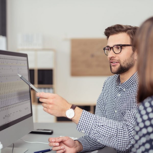 geschäftsmann erklärt seiner kollegin etwas am computer