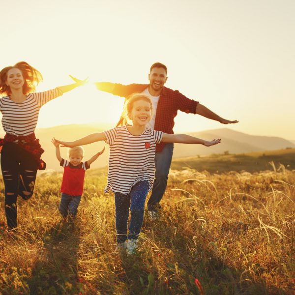 Happy family: mother, father, children son and  daughter on nature  on sunset